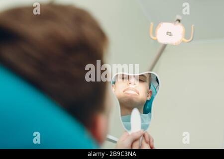 Dentisterie. Dentiste et patient. Clinique dentaire. Patient regardant sur le sourire pour se mettre en miroir. Banque D'Images