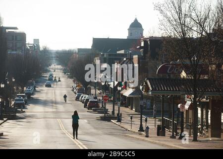 Bloomington, États-Unis. 23 mars 2020. Une femme se tient au milieu de Kirkwood Avenue près de l'Université de l'Indiana à quelques heures seulement après que le gouverneur de l'Indiana Eric Holcomb a annoncé un ordre « à domicile » pendant l'urgence de Covid-19/Coronavirus à Bloomington, Ind. Seven Hoosiers sont déjà morts du virus, et plus de 200 ont été malades. L'Université de l'Indiana a envoyé des étudiants à la maison pour le semestre, et il enseigne pratiquement des cours. Crédit: SOPA Images Limited/Alay Live News Banque D'Images