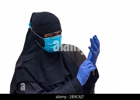 Femme musulmane portant un masque médical avec gants de main - rester à la maison, être sûr et sûr les autres. Concept de quarantaine COVID-19 ou Coronavirus. Banque D'Images