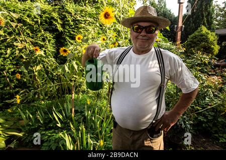 jardinier dans son jardin avec pot d'arrosage Banque D'Images