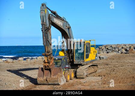 Digger de front en mouvement de la Terre jaune jouant avec un ami jaune plus petit pour des raisons de sécurité Banque D'Images