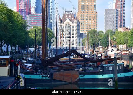 Vieux voiliers à fond plat dans le vieux port intérieur de Rotterdam avec de multiples bâtiments en hauteur en arrière-plan Banque D'Images