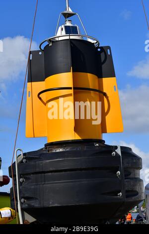 Grande bouée jaune et noire vive suspendue à une grue en prévision du levage à bord d'un navire Banque D'Images