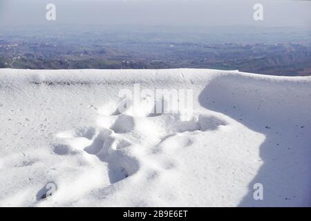 Empreintes humaines dans la neige profonde le jour ensoleillé . Banque D'Images