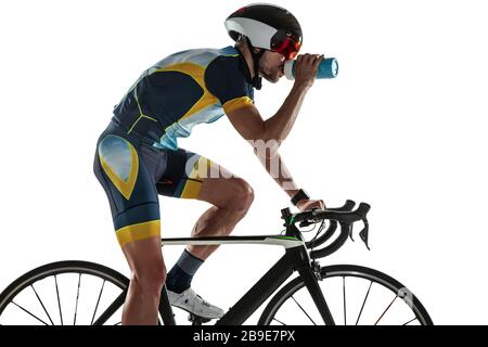 Entraînement de cycle d'athlète masculin Triathlon isolé sur fond blanc de studio. Triathlète de race blanche pratiquant le cyclisme portant de l'équipement sportif. Concept de mode de vie sain, sport, action, mouvement. Banque D'Images