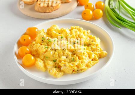 Œufs brouillés et tomates sur fond de pierre blanche Banque D'Images