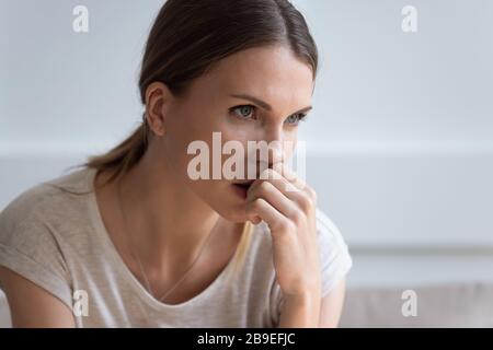 La tête a bouleversé la jeune femme réfléchie regardant à distance Banque D'Images