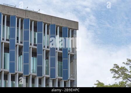 Panneaux solaires verticaux réglables ou mobiles sur le côté d'un campus TAFE dans la banlieue d'Artarmon, Nouvelle-Galles du Sud, Australie Banque D'Images