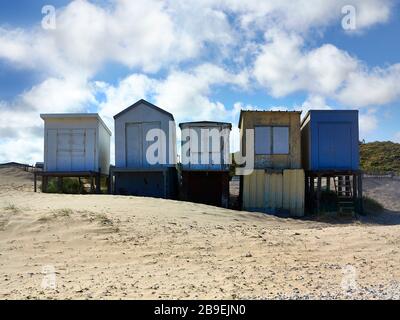 5 cabanes de plage de shabby sur la plage de sable le jour ensoleillé avec ciel bleu Banque D'Images