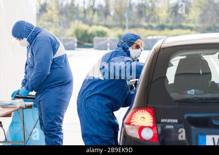 24 mars 2020, Sarre, Saarlouis: Deux médecins prennent des écouvillons dans une station d'essai au volant dans le parking des usines Ford de Saarlouis. Le matin, les premières stations de conduite de la Sarre, dans lesquelles des tests pour le virus corona sont effectués, ont été mises en service. Photo : Oliver Dietze/dpa Banque D'Images