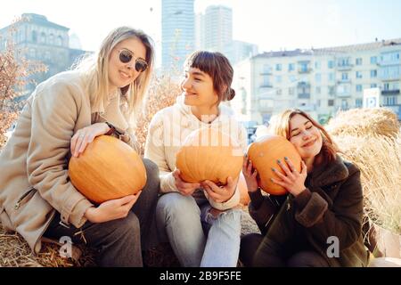 Les filles tient les citrouilles dans les mains sur le fond de la rue. Banque D'Images