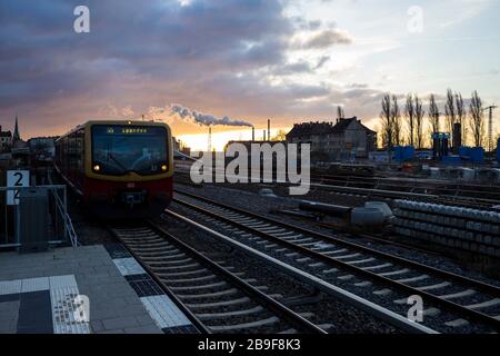 Un train SBahn arrivant à la plate-forme de la gare au lever du soleil à Berlin, en Allemagne Banque D'Images