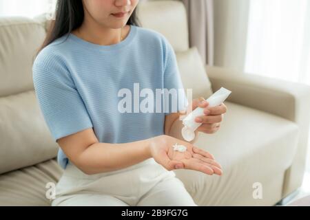 Femme asiatique utilisant la lotion ou hydrater comme main de leur vie quotidienne pour la protection de la peau pour devenir sèche et irritée après l'utilisation de gel antiseptique d'alcool, Banque D'Images