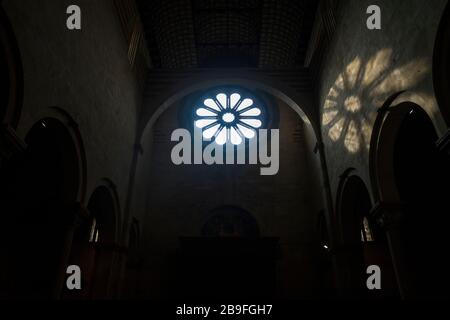 La lumière de la fenêtre rose tombe sur un mur intérieur à l'intérieur de la basilique San Zeno de Vérone, en Italie Banque D'Images