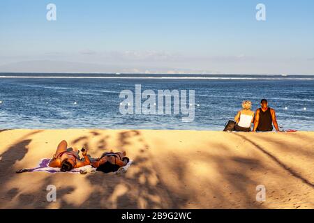 Les visiteurs peuvent bronzer sur la plage, la plage de Sanur, Bali, Indonésie. Banque D'Images