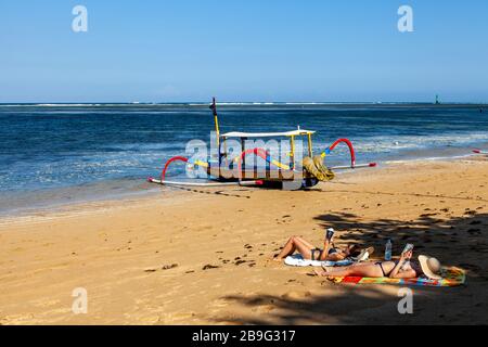 Les visiteurs peuvent bronzer sur la plage, la plage de Sanur, Sanur, Bali, Indonésie. Banque D'Images