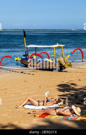 Les visiteurs peuvent bronzer sur la plage, la plage de Sanur, Sanur, Bali, Indonésie. Banque D'Images