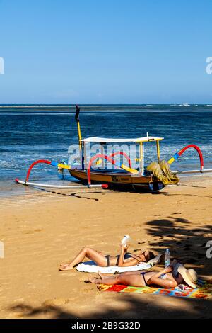 Les visiteurs peuvent bronzer sur la plage, la plage de Sanur, Sanur, Bali, Indonésie. Banque D'Images