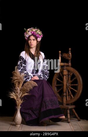 Vêtements nationaux ukrainiens modernes. Portrait d'une belle femme avec des readlocks dans une robe nationale brodée sur un fond noir. Ukrainien Banque D'Images