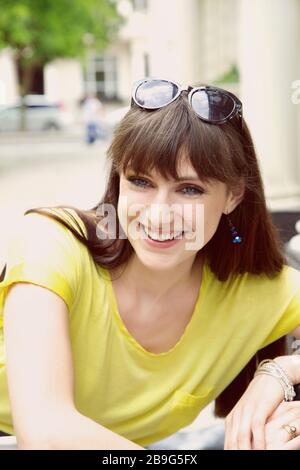 Portrait heureuse jeune femme sur le trottoir Banque D'Images