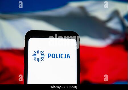 Dans cette photo, un logo Policja (police polonaise) apparaît sur un smartphone.le drapeau national polonais est affiché comme arrière-plan. Banque D'Images