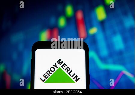 Dans cette illustration photo, un logo Leroy Merlin apparaît sur un smartphone.un graphique de la bourse est affiché en arrière-plan. Banque D'Images