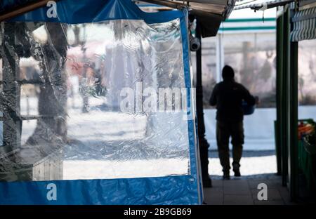 24 mars 2020, Bavière, Munich: Un Trader porte une boîte de fruits sur le Viktualienmarkt, autrement presque déserté. Photo: Sven Hoppe/dpa Banque D'Images