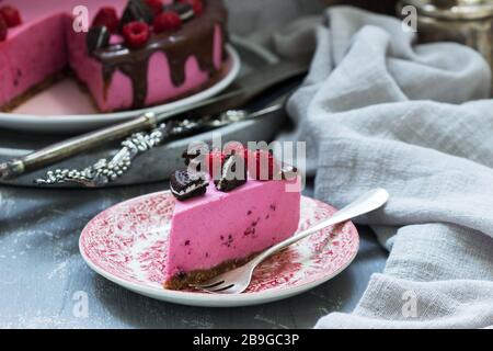 Gâteau à la mousse de curricassis décoré de petits gâteaux et de framboises. Banque D'Images