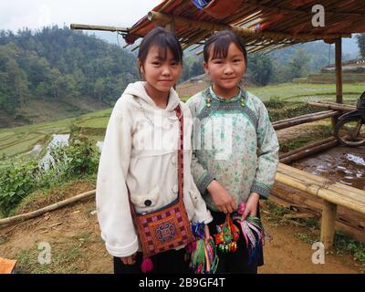 Deux jeunes filles vendant des bracelets aux touristes trekking à Sapa, au Vietnam Banque D'Images