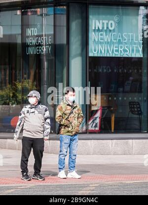 Newcastle upon Tyne, Royaume-Uni, 22 mars 2020. Deux mâles asiatiques attendent de traverser une route portant des masques de protection pendant le covid-19 pandénique. Joseph Gaul/Alay News Banque D'Images