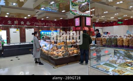 (200324) -- SHANGHAI, le 24 mars 2020 (Xinhua) -- les clients font leurs achats au premier magasin alimentaire de Shanghai, à Shanghai, en Chine orientale, le 24 mars 2020. Shanghai a annoncé la dégradation de son intervention d'urgence à la nouvelle épidémie de coronavirus du niveau I au niveau II à partir de mardi. (Photo de Wang Xiang/Xinhua) Banque D'Images