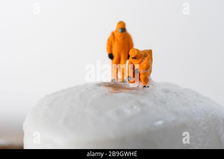 Image conceptuelle pour Coronavirus avec personnes miniatures sur une barre de savon dans les combinaisons hazmat pour tester les bactéries. Banque D'Images