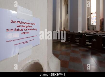 24 mars 2020, Bavière, Munich: Un feuillet de papier avec l'inscription "l'eau Sainte a été temporairement retirée pour protéger contre l'infection" peut être vu dans la Frauenkirche désertée. Photo: Sven Hoppe/dpa Banque D'Images