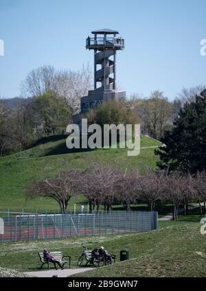 Fribourg, Allemagne. 24 mars 2020. Les gens s'assoient sur des bancs à distance dans le Seepark. Les gens sont appelés à garder leur distance à cause du coronavirus. Crédit: Patrick Seeger/dpa/Alay Live News Banque D'Images