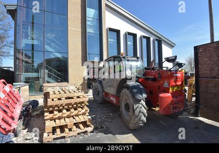Un travailleur de la construction conduit des machines sur un site de construction géré par le conseil à Billericay Essex, le lendemain que le Premier ministre Boris Johnson a mis le Royaume-Uni en position de verrouillage pour aider à freiner la propagation du coronavirus. Banque D'Images