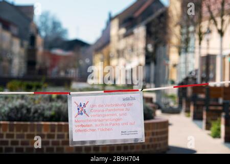 Luckenwalde, Allemagne. 24 mars 2020. Un avis joint à un ruban rouge et blanc dans la zone piétonne Breite Straße informe sur l'interdiction de la foule de personnes en raison de la pandémie de Corona. La ville veut utiliser le marquage pour faire respecter l'interdiction dans les parcs et les aires publiques. Crédit: Soeren Stache/dpa-Zentralbild/dpa/Alay Live News Banque D'Images