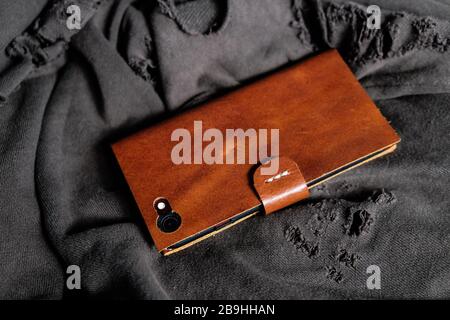 Le travail de fabrication de la housse en cuir pour téléphone est réalisé sur un fond en tissu Banque D'Images