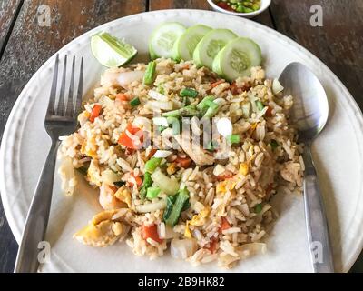 Riz frit avec calmar de crevettes aux fruits de mer et œufs sur table en bois Banque D'Images
