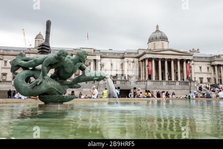 Trafalgar Square et la National Gallery. Les touristes se rassemblent par les fontaines dans le quartier touristique populaire de Londres. Banque D'Images