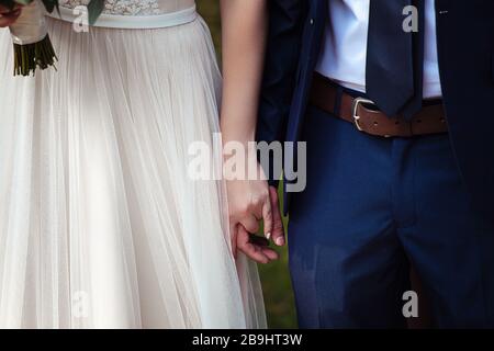 Mariée et marié tenant doucement les mains pendant la cérémonie de mariage Banque D'Images