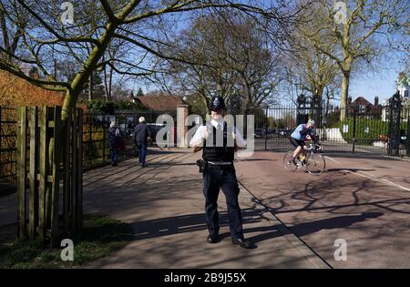 Un policier aux portes du parc Richmond le lendemain que le Premier ministre Boris Johnson a mis le Royaume-Uni en position de verrouillage pour aider à freiner la propagation du coronavirus. Banque D'Images