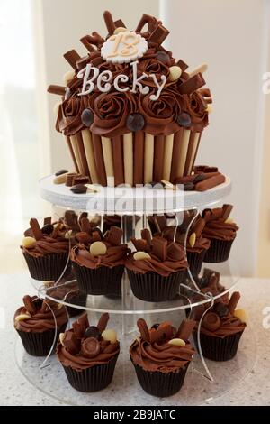 Un délicieux gâteau d'anniversaire au chocolat 18 en forme de cupcake, avec le mot Becky dessus, et d'autres cupcakes au chocolat Banque D'Images