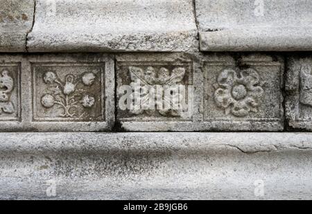Décorations florales en pierre sculptées sur le mur d'une église médiévale en Italie Banque D'Images