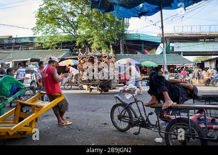 Les porteurs et les rickshaw se reposent tout en attendant les clients dans les rues du marché public Carbon Banque D'Images