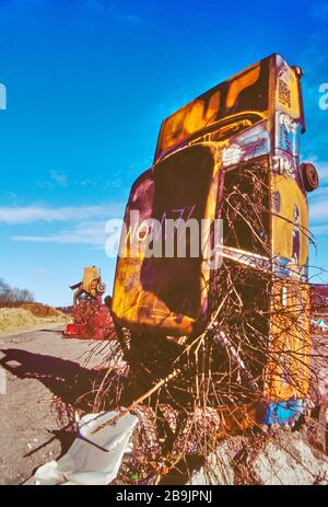 Carhenge à Pollock Park, Glasgow 1994. Une collection de voitures rougines a été boulevertie et couverte de graffitis pour protester contre la construction de l'autoroute M77. Banque D'Images