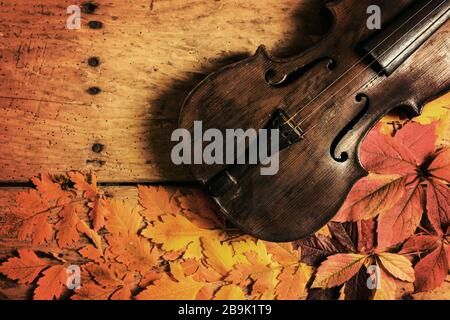 Le vieux violon et l'automne partent sur une ancienne table en bois rustique - vue de dessus, espace de copie Banque D'Images