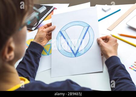 Le concepteur dessine une esquisse du logo d'une marque. Banque D'Images