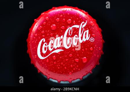 Kharkiv, Ukraine, 22 mars 2020: Gros liège de coca-cola sur fond noir. Gouttes d'eau sur la boisson d'origine. Bouteille de cola en verre. Vue de dessus. Il Banque D'Images