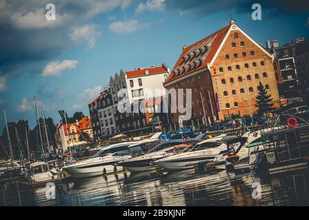 Yachts modernes amarrés dans le port de plaisance de Gdansk sur la rivière New Motlawa à Gdansk, Pologne avec de vieux bâtiments en arrière-plan Banque D'Images