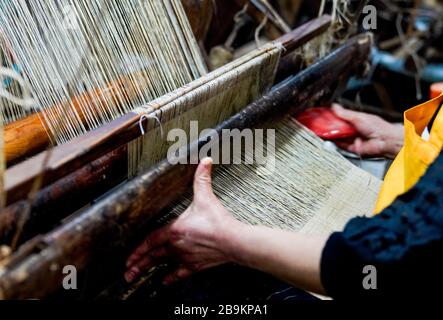 (200324) -- CHONGQING, le 24 mars 2020 (Xinhua) -- une femme fait du linge de maison de gazon de Rongchang, également appelé Rongchang Xiabu, lors d'un atelier dans le district de Rongchang à Chongqing, dans le sud-ouest de la Chine, le 23 mars 2020. Le linge de gazon de Rongchang est un artisanat chinois traditionnel avec une riche histoire. C'est une sorte de tissu fait de ramie purement à la main, et célèbre pour sa texture douce, fine, plate et de qualité fine. Parce que ce tissu garde habituellement le corps frais dans l'été chaud, il est également appelé Xiabu (littéralement, le tissu d'été). Grâce à des mesures de prévention des épidémies globales, les industries de fabrication de Xiabu y ont Banque D'Images